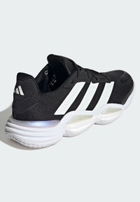 Black athletic shoe with a textured upper, white three-stripe design, padded collar, and a cushioned, curved white sole for support.