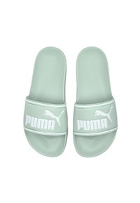 Sandales glissantes vertes avec une finition lisse et mate. La large sangle présente un logo "PUMA" blanc bien en vue et une illustration d'un chat bondissant.