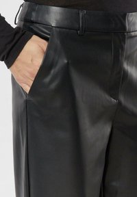 Czarne skórzane spodnie o gładkiej fakturze, z boczną kieszenią, dopasowanym paskiem w talii oraz wyraźnymi kantami zapewniającymi strukturalne dopasowanie.
