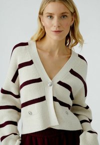 Cremefarbenes und burgunderrotes gestreiftes Cardigan mit V-Ausschnitt, gerippter Textur und silberfarbigen Knöpfen auf der Vorderseite. Kurzes Design.