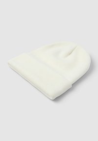 Biała, dziana czapka beanie z podwiniętym klapkiem, leżąca płasko na jasnoszarym tle.