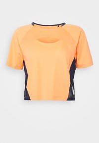Top sportivo a maniche corte e cropped di un vivace arancione con pannelli laterali blu navy. Presenta un collo rotondo e un dettaglio con aperture frontali. Tessuto texturizzato.