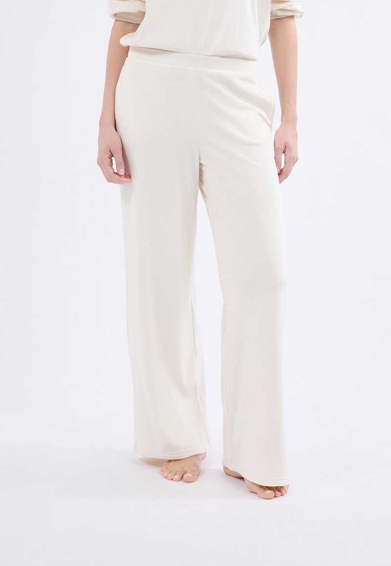 Pantalones de pierna ancha color crema, hechos de una tela suave, con una cintura alta y un diseño fluido y suave.
