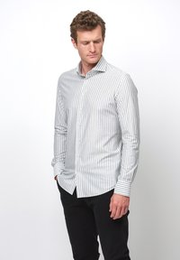 Lichtgrijs en wit gestreept lange mouwen shirt met een button-down kraag, met een slim fit en knoopsluiting. Gekleed met zwarte broek.