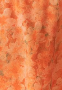 Tissu doux avec un motif floral orange et corail clair, présentant des formes de fleurs abstraites et des touches vertes subtiles.