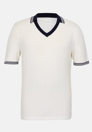 Krämfärgad kortärmad polo med en marinblå V-halskrage, prydd med vita och marinblå ränder på kragen och ärmarna. Strukturtröjan har en ribbad design.
