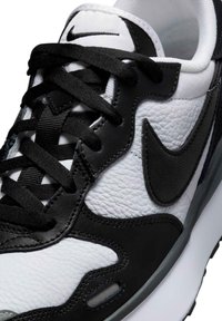 Črno-bele Nike superge z teksturiranim usnjem, gladkimi detajli, črnimi vezalkami in kontrastnim dizajnom swoosh.
