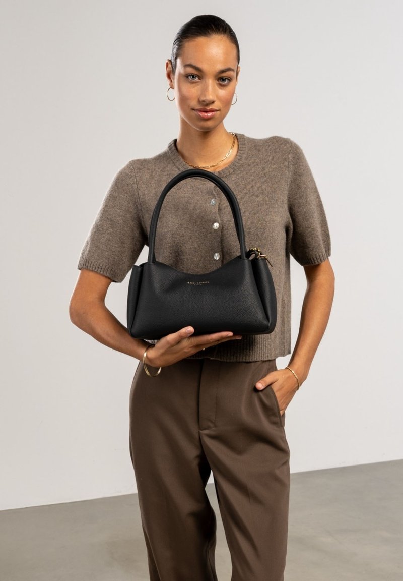 Black leather handbag with a structured silhouette, dual rounded handles, and a subtle gold logo. Textured surface enhances visual interest.