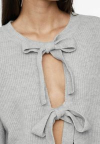 Cardigan grigio lavorato a maglia con scollo tondo, caratterizzato da un dettaglio a occhiello frontale con due fiocchi in tessuto. Texture morbida, motivo a coste visibile.