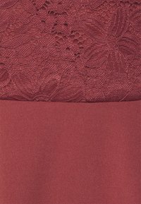 Vestido bordo com um corpete de renda texturizada e uma parte inferior de tecido suave. Padrões florais intrincados na renda adicionam detalhe ao design.