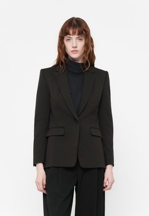 Blazer noir à coupe ajustée, avec revers crantés, deux poches avant et une fermeture à un bouton. Texture lisse, design structuré.