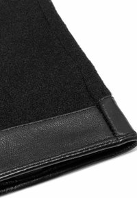 Czarna tkanina o miękkiej, teksturowanej powierzchni, z gładkim, czarnym skórzanym wykończeniem wzdłuż krawędzi. Czysty design bez widocznych wzorów.