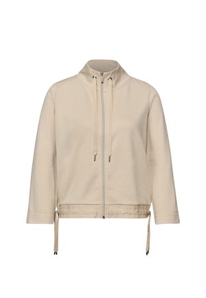 Veste beige zippée avec col montant, manches longues, cordons réglables au col et à l'ourlet, en tissu doux.