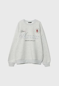 Sweat-shirt gris clair avec le texte « Monaco Grand Circuit », un emblème de bouclier de course rouge et noir, et un petit graphique de signature sur la poitrine.