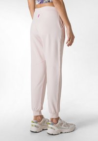 Ljust rosa joggers med en mjuk textur, avsmalnande passform, sidofickor och en liten rosa logotyp bak. Matchas med ljusa sneakers.
