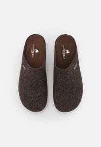 Zapatillas de fieltro de lana marrón con parte trasera cerrada, textura suave y un sutil logo de Shepherd en la plantilla. Diseño simple y redondeado.