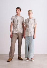 Beige mønstrede kortermede topper, grå satinbukser og en lyseblå denimskjørt med frontsplitt. Fottøy varierer mellom uformelt og formelt.
