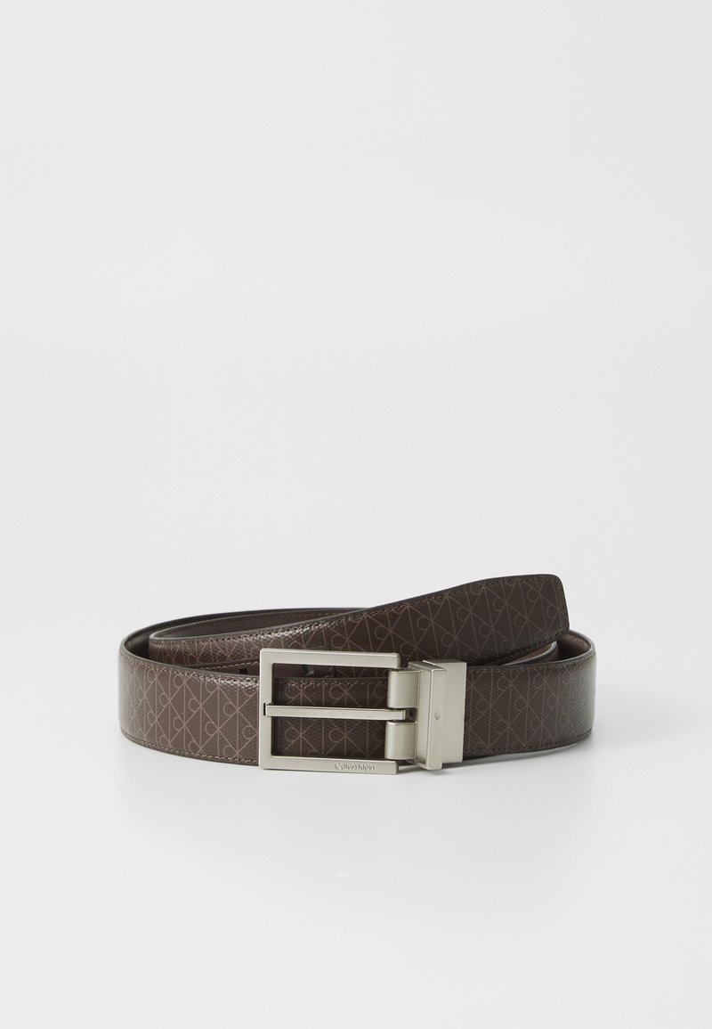 Brown leather belt featuring embossed pattern and a rectangular silver metal buckle with brand name. Smooth texture, classic design.