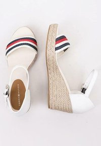 Sandali wedge espadrillas bianchi con ampie bande a strisce in blu e rosso, soletta in juta intrecciata e cinturino alla caviglia regolabile con fibbia.