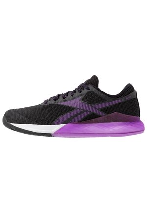 Czarno-fioletowy sportowy sneaker z siateczkową cholewką, fioletową podeszwą i czarnymi sznurowadłami, pokazany z lewej strony na białym tle.