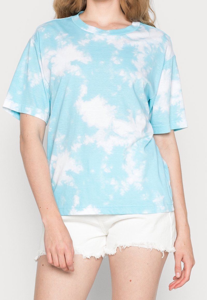 Błękitny t-shirt z krótkim rękawem w biały wzór tie-dye. Posiada okrągły dekolt i luźny krój, wykonany z miękkiej bawełny.