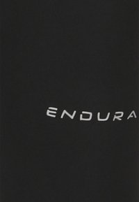 Sort stof med hvid tekst "ENDURA" trykt med store bogstaver, centreret i det synlige område.