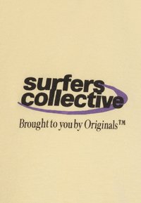"Text 'surfers collective' in bold black with a purple swoosh, and smaller text 'Brought to you by Originals™' on beige fabric."
