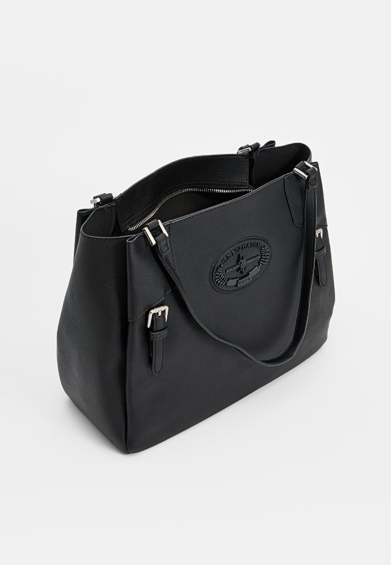 Schwarze Leder-Tote mit Reißverschluss, doppelten Griffen und einem erhabenen Emblem. Besitzt eine strukturierte Form und eine glatte Textur.