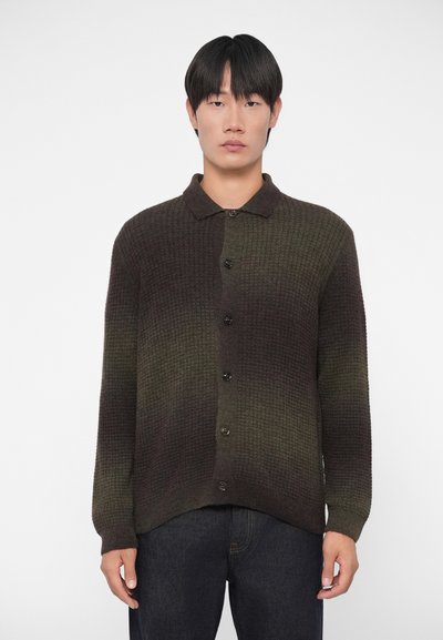Cardigan tricoté dans des teintes dégradées de vert et de marron, avec un col, des boutons sur le devant et des poignets côtelés. Tissu texturé avec un motif à carreaux.