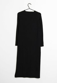 Robe noire longue à côtes en tissu extensible, avec des manches longues et un col rond, accrochée sur un crochet noir contre un fond blanc.