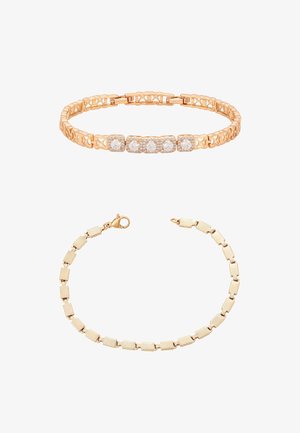 Góra: złota bransoletka z pięcioma dużymi okrągłymi diamentami; dół: złota bransoletka z fakturą i ogniwami, z zapięciem typu lobster, obie na białym tle.