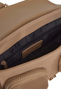 Borsa a tracolla in pelle color tan con una superficie liscia, tasca con zip, interno foderato in nero e placchetta con logo. Presenta un delicato dettaglio di cucitura.