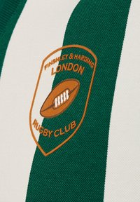 Groen en wit gestreepte rugbyshirt met een oranje geborduurd embleem met "FINSHLEY & HARDING," "LONDEN," en een rugbybalontwerp.