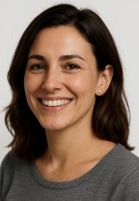 Donna con capelli castano medio e tonalità di pelle calda, che indossa un top grigio e orecchini a forma di cuore dorati, sorridendo su uno sfondo neutro.