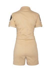Tuta color khaki con maniche corte, tasche frontali e vita aderente. Il retro presenta un colletto alto e maniche arrotolate con dettagli a toppa.
