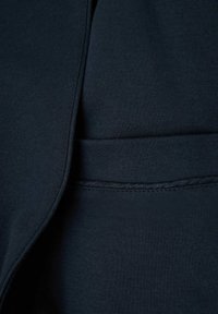 Námorně modrá bavlněná tkanina s hladkým povrchem. Má jednoduchý design s bezproblémovým zakončením a jemným švem podél okrajů.