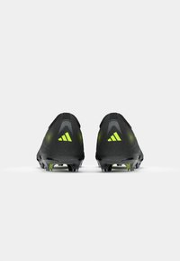 Black soccer cleats with a textured upper, featuring neon green accents and a streamlined design. TPU studs for traction.