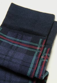Marinblå ternede sokker med ribbede manchetter, prydet med et geometrisk mønster i blå, grøn og rød. Strikket stof med en glat overflade.