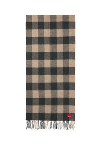 Wollen plaid sjaal met een zwart en beige ruitpatroon, voorzien van franjes aan de randen. Inclusief een klein rood label in de hoek.