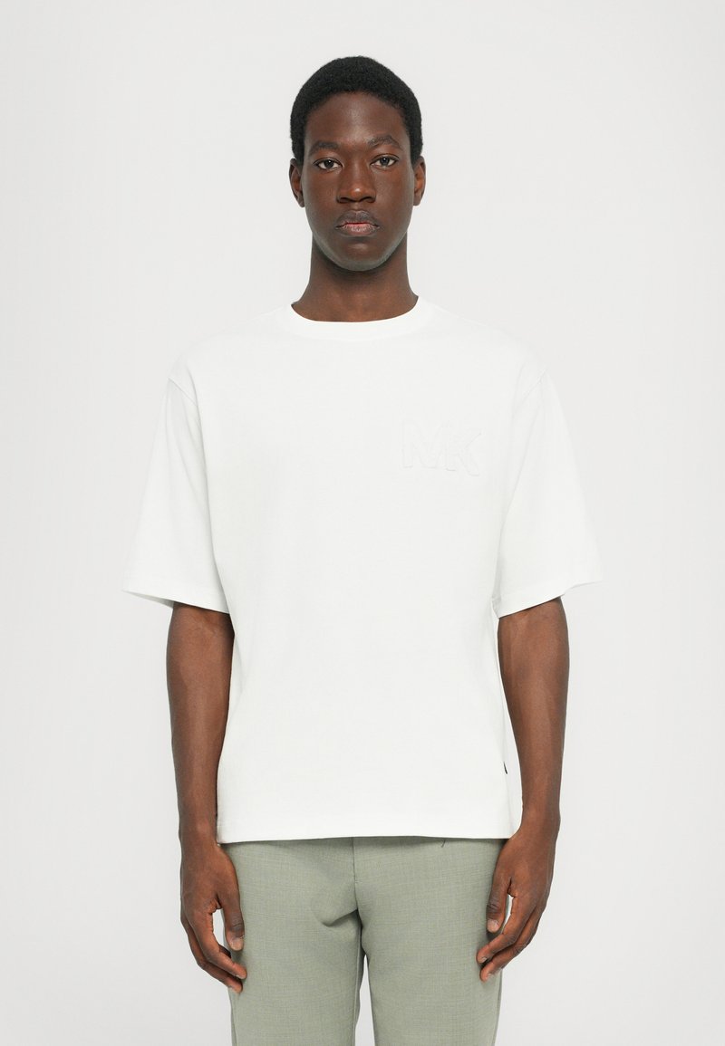 White short-sleeve T-shirt with a crew neck, featuring a subtle embossed "MK" logo on the chest and a relaxed fit.