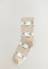 Beige sok met een patroon van witte schapen met zwarte accenten. Gladde textuur, lengte tot halverwege de kuit en geribbelde boord.