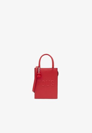 Rote Ledertasche mit geprägtem "TOUS"-Logo, strukturierte rechteckige Form, kurze Griffe und abnehmbarer Schultergurt. Mit einem Bären-Anhänger.