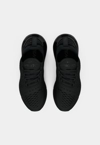 Svarta sportskor med en ovandel i mesh, med ett perforerat mönster, vadderad sula och snören, där varumärket är synligt på tungan.