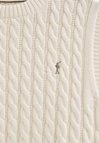 Grob gestrickter Pullover in Off-White mit geripptem Halsausschnitt. Ausgestattet mit aufwendigen geflochtenen Mustern und einem kleinen, braunen gestickten Logo.