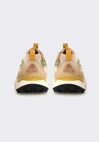 Braune und grüne Sneakers mit einer strukturierten Oberseite, geschichteter Gestaltung und Zuglasche. Sie verfügen über eine weiße Zwischensohle und eine robuste schwarze Außensohle.