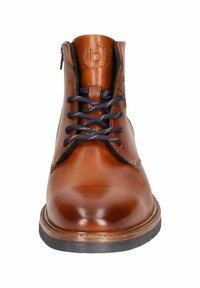 Brown leather ankle boot with navy laces, round toe, textured surface, and a contrasting rubber sole. Features embossed logo on tongue.