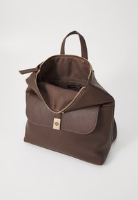 Sac à dos en simili cuir marron avec une forme structurée, fermeture éclair dorée et un rabat avant sécurisé par un fermoir en métal doré. Intérieur doublé.
