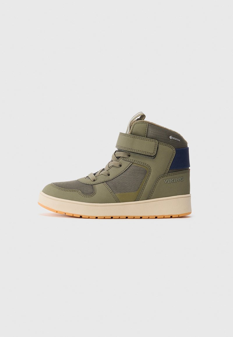 Olíva zöld magasszárú sneaker bézs talppal, tépőzárral, hálós panelek, Gore-Tex címkével és tengerészkék sarkú részlettel.
