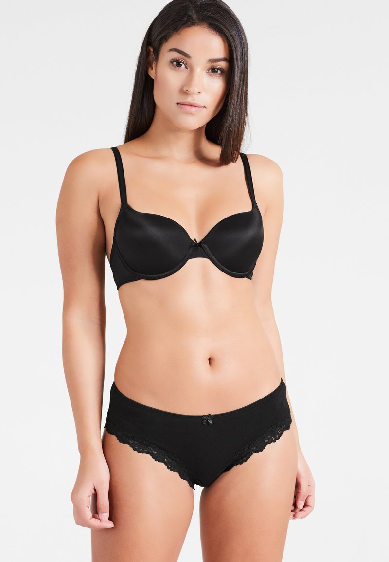Bikini-Set mit schwarzem Spitzenbesatz und gepolstertem, drahtlosem BH, aus glattem Stoff, mit verstellbaren Trägern und einem kleinen Schleifchen in der Mitte.