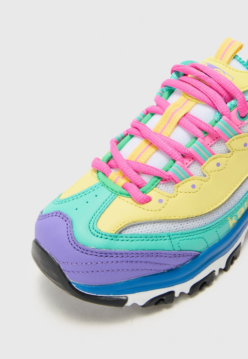 Flerfärgad sneaker med ett mesh-överdel i nyanser av gult, grönt, rosa och lila. Tjock gummisula med strukturerade detaljer.